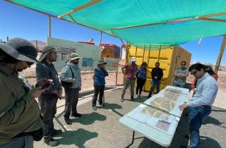 Equipo del SEA y participantes revisando el plano del proyecto en el sitio de la visita técnica en Taltal.